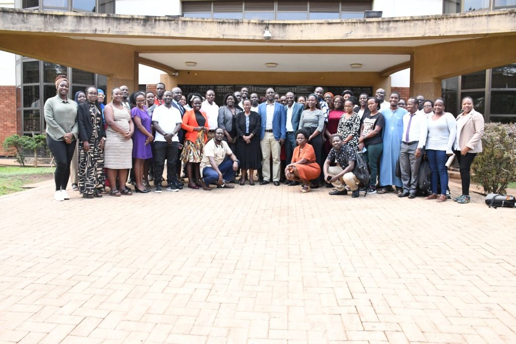 Director Prof. Kikooma franked by Dr. Mujimu in a group photo with doctoral students.